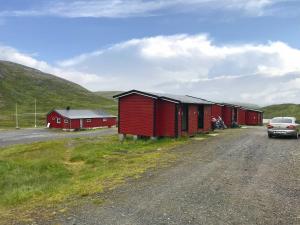 SkarsvågHytte Camp Nordkapp - Red的停在一排红楼旁边的汽车