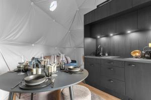塞尔福斯Golden Circle Domes - Glamping Experience的厨房配有带盘子和酒杯的桌子