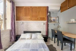 马赛Studio idéal pour deux voyageurs sur Marseille的卧室配有一张床和一张桌子及椅子