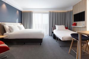 迪温特Holiday Inn Express & Suites - Deventer, an IHG Hotel的酒店客房设有两张床和一张桌子。