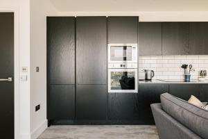 伦敦CitySpace Acton的厨房配有黑色橱柜和沙发