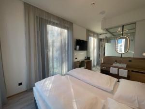 林茨BEE GREEN Linz Self-Check-in-Hotel的卧室配有一张白色大床和镜子