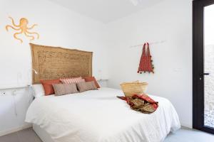 波里斯-德阿沃纳Home2Book Design & Breathtaking Sea Views El Porís的卧室配有白色床,墙上挂着圣诞树