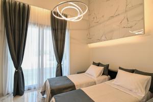 斯塔夫罗斯瑞西欧斯酒店的配有窗户和吊灯的客房内的两张床