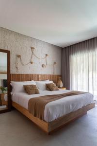 圣米格尔-杜斯米拉格里斯POUSADA ZAYA的一间卧室配有一张大床和木制床头板