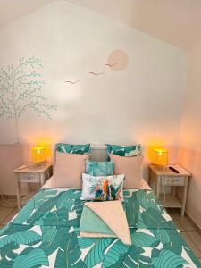 圣吉尔莱班海滩酒店的一间卧室配有一张带绿色和白色棉被的床