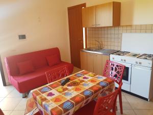 罗迪-加尔加尼科Dal Cavallaro的厨房配有桌子和红色沙发