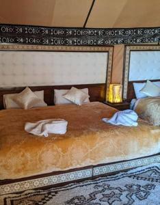 梅尔祖卡Luxury Desert Camp的一间卧室配有一张大床和毛巾