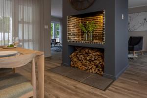 斯泰伦博斯Villa Stellenbosch的客厅里的壁炉,有一堆木柴