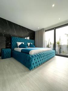 ArcozeloNova Mansão LA的一间卧室配有一张蓝色的大床和蓝色床头板