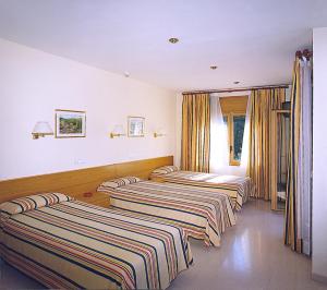 瑞达里那马略齐内斯旅馆的三个床在一间房间里排成一排
