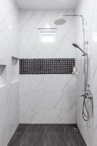 七岩Norway Poolvilla的浴室设有白色大理石瓷砖和淋浴。