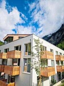 索尔登All-Suite Resort Zwieselstein - Sölden的公寓大楼设有木制阳台,享有山脉的背景