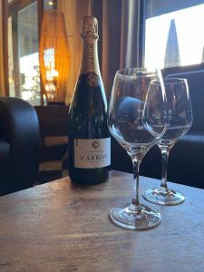 香槟沙隆波特戴塔尹酒店的桌子上放有一瓶葡萄酒和两杯酒