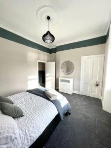 亚历山德里亚Stevenson Apartment的卧室配有白色的床和蓝色的墙壁