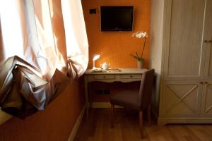 科洛尔诺洛坎达斯汤达酒店的客房设有书桌、电视和椅子