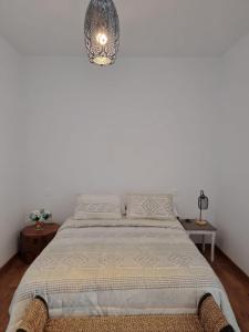 纳萨雷特Habitacion Alunita的卧室配有一张白色墙壁的床