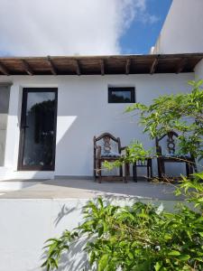 纳萨雷特Habitacion Alunita的庭院内白色的房子,配有两把椅子