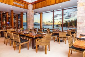 桑迪湾安东尼的钥匙度假酒店的餐厅设有桌椅和大窗户。