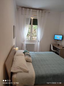 博洛尼亚Casailaekobe的一间卧室配有一张床、一张书桌和一个窗户。