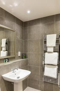 巴洛赫Cameron House Lodges的浴室配有盥洗盆、镜子和毛巾