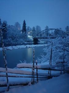 HammarstrandAmmeråns Fiskecamp的一座在雪中覆盖的河流上的桥梁