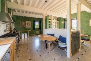 博恩孔文托Villa Fragranza - Homelike Villas的厨房设有绿色的墙壁和木桌