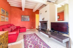 博恩孔文托Villa Fragranza - Homelike Villas的客厅设有红色的沙发和壁炉