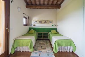 博恩孔文托Villa Fragranza - Homelike Villas的两张床位于带绿色和白色墙壁的客房