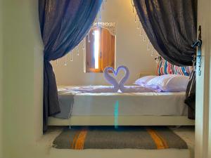 米多恩Hôtel Djerba Authentique - Au centre de Midoun的一间卧室配有一张带天鹅的床