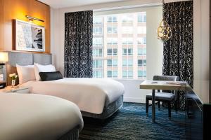 芝加哥芝加哥壮丽大道索菲特酒店的酒店客房设有两张床、一张书桌和一个窗户。