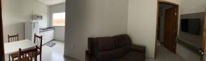 博尼图Confort Flats的客厅配有椅子、桌子和电视