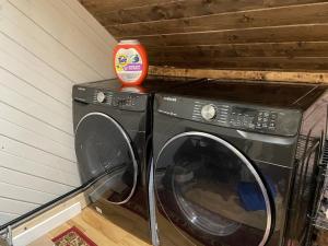 榉木山Apres’ Chalet的洗衣机和烘干机,上面有一个橙色容器