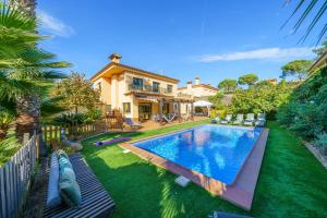罗列特海岸VIlla Jaruco Lux, exclusiva zona residencial con Piscina & Aircon的一个带游泳池和房子的后院