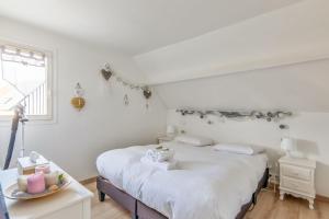 卡布尔Charming duplex with big terrace- Cabourg - Welkeys的白色的卧室设有床和窗户