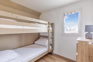卡布尔Charming duplex with big terrace- Cabourg - Welkeys的一间卧室设有两张双层床和一扇窗户。