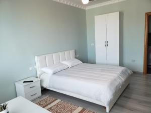 地拉那Agroni Rooms的卧室配有白色的床和白色橱柜