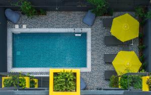 海若克利欧3 Pines Design Living的享有游泳池的顶部景色,设有黄色桌子和遮阳伞