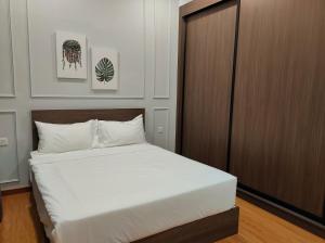 乔治市New 2BR Georgetown Warm and Lovely Homestay 10pax-无敌美景两房民宿 Beacon Executive Suite的卧室配有白色的床和木制橱柜。