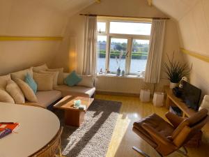 济里克泽Zierikzee Appartement ZZ 41 B&B的带沙发、桌子和窗户的客厅