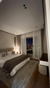 多哈Beachfront Luxury Apartment-The Home-Pearl Island的一间大卧室,配有一张大床和一个窗户
