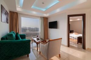 瓦迪穆萨Petra Elite Hotel的一间带绿色沙发的客厅和一间卧室