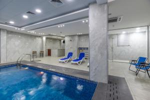 瓦迪穆萨Petra Elite Hotel的一个带蓝色椅子的游泳池