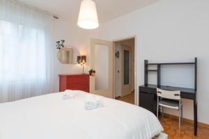 米兰[Mimmi Apartment] Zurigo 12的一间卧室配有一张床、一张书桌和一台电视