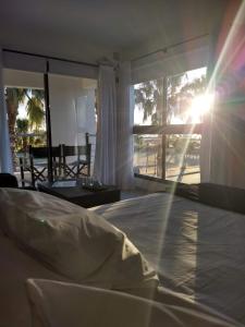 米拉马尔Andaluhe Posada的卧室配有一张床,窗户上阳光照耀着