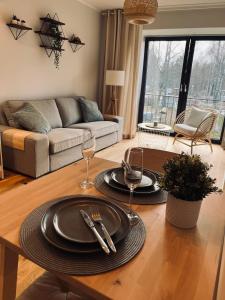 ĶesterciemsAlbatross Beach Apartment - SPA, Sea and Forest的客厅配有带盘子和酒杯的桌子