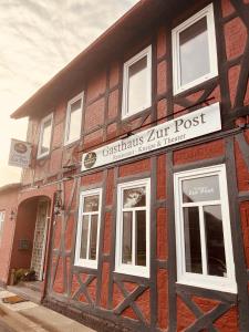UetzeGasthaus Zur Post的一座旧砖砌的建筑,上面有标志