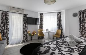 布加勒斯特Lion's Unirii Apartment的卧室配有一张床和一张桌子及椅子