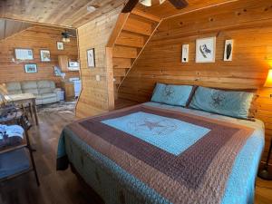 弗雷德里克斯堡Walnut Canyon Cabins的木制客房内的一间卧室,配有一张床