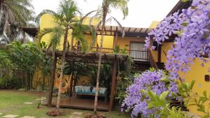 伊塔卡雷Conchas do Mar Residence的前面有紫色花的房屋